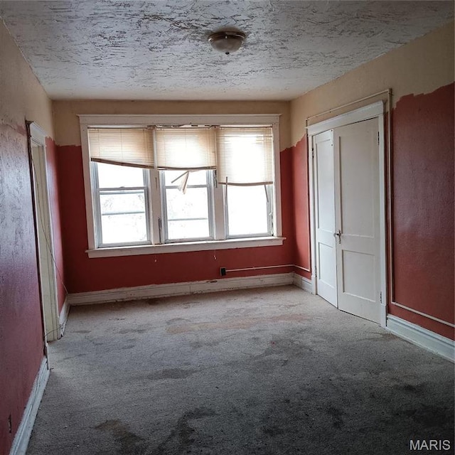 4341 Shreve Ave, Saint Louis, MO 63115 - empty room featuring light carpet, baseboards, and a textured ceiling