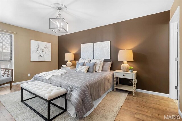 13453 Coliseum Dr Unit E, Chesterfield, MO 63017 - bedroom featuring a chandelier, baseboards, and light wood finished floors