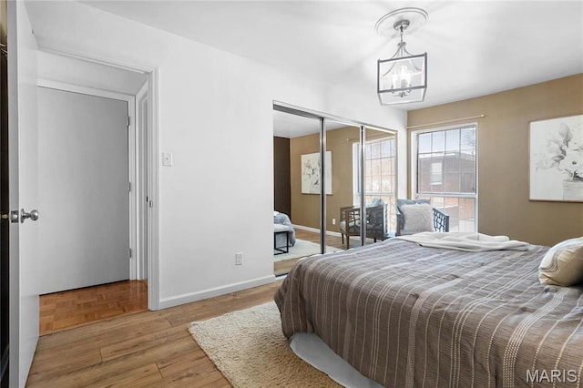 13453 Coliseum Dr Unit E, Chesterfield, MO 63017 - bedroom featuring a chandelier, baseboards, a closet, and wood finished floors