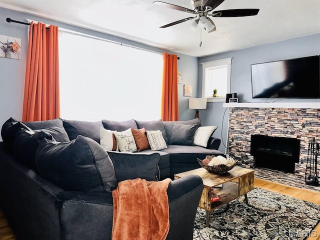 4983 Chippewa St, Saint Louis, MO 63109 - living room with wood finished floors, a ceiling fan, and a stone fireplace