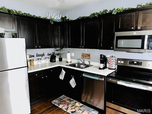 4983 Chippewa St, Saint Louis, MO 63109 - kitchen with stainless steel appliances, a sink, light countertops, and dark wood finished floors