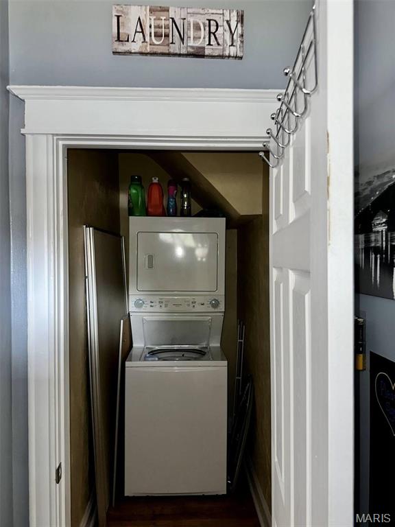 4983 Chippewa St, Saint Louis, MO 63109 - laundry room with stacked washing machine and dryer and dark wood finished floors