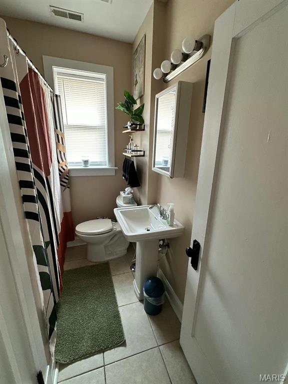 4983 Chippewa St, Saint Louis, MO 63109 - bathroom featuring tile patterned flooring, toilet, baseboards, and a shower with shower curtain