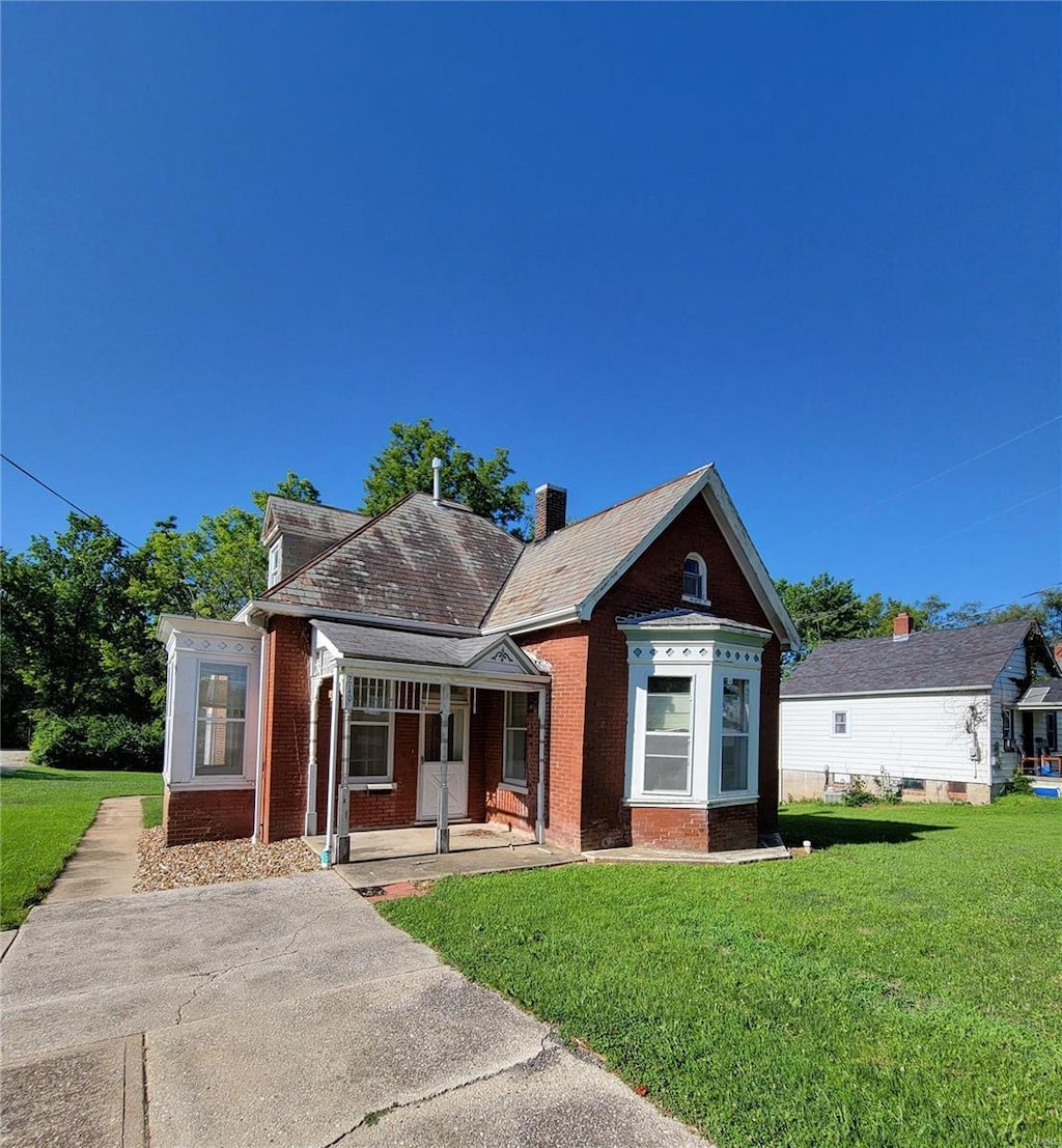 216 E Walton St, Warrenton, MO 63383 - bungalow-style home with brick siding, a front yard, and covered porch
