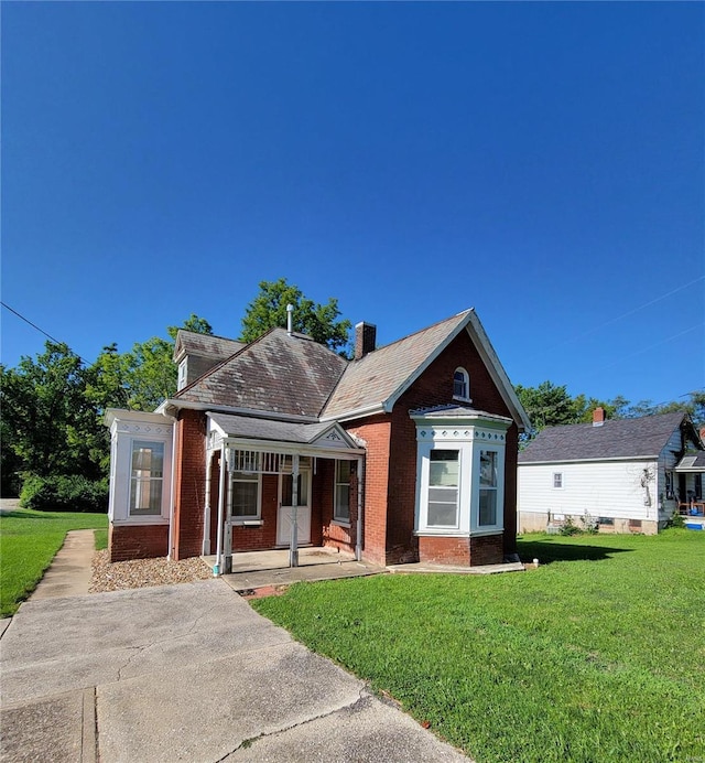 bungalow-style home with brick siding, a front yard, and covered porch