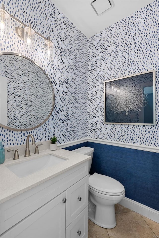 bathroom featuring wallpapered walls, toilet, tile patterned floors, vanity, and baseboards