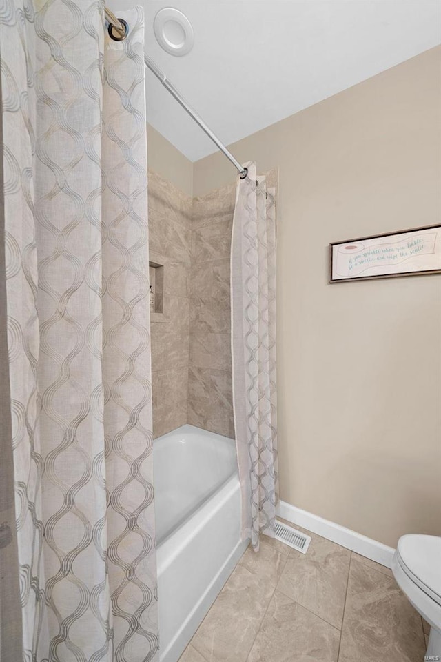 bathroom featuring shower / tub combo with curtain, tile patterned floors, baseboards, and toilet