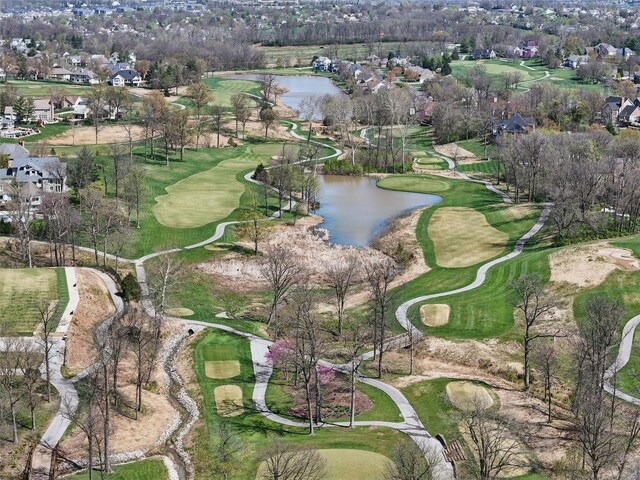 aerial view of property and surrounding area featuring a nearby body of water, a golf club, and nearby suburban area
