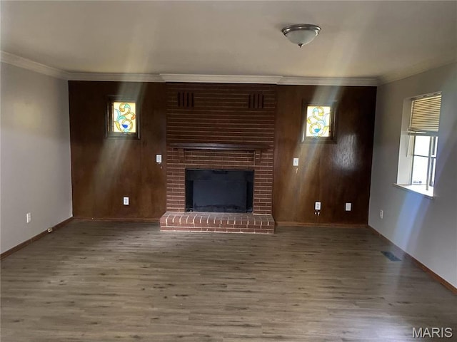 1445 Fairmeadows Ln, Saint Louis, MO 63138 - unfurnished living room featuring wood finished floors, baseboards, crown molding, a brick fireplace, and wood walls