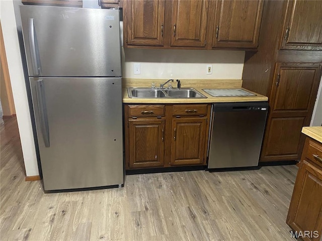 1445 Fairmeadows Ln, Saint Louis, MO 63138 - kitchen featuring stainless steel appliances, a sink, light countertops, and light wood-style floors