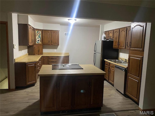1445 Fairmeadows Ln, Saint Louis, MO 63138 - kitchen with stainless steel appliances, light wood-style flooring, light countertops, and a kitchen island