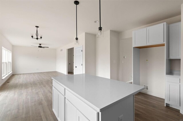 1741 Martingale Ln, Eureka, MO 63025 - kitchen with dark wood-style floors, a kitchen island, ceiling fan, hanging light fixtures, and white cabinets