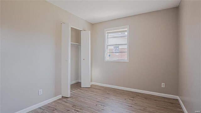 1370 Reale Ave, Saint Louis, MO 63138 - unfurnished bedroom with wood finished floors, baseboards, and a closet