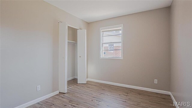 1370 Reale Ave, Saint Louis, MO 63138 - unfurnished bedroom featuring wood finished floors, baseboards, and a closet