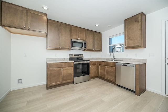 103 Cardow Dr Unit 169-605, Ofallon, MO 63368 - kitchen featuring appliances with stainless steel finishes, a sink, light wood-style floors, light countertops, and recessed lighting