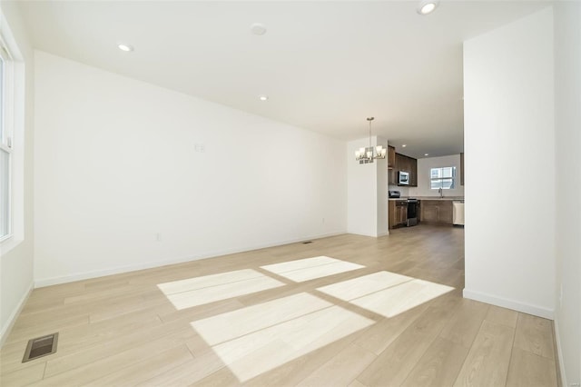 103 Cardow Dr Unit 169-605, Ofallon, MO 63368 - unfurnished living room with a chandelier, light wood-type flooring, baseboards, recessed lighting, and a sink