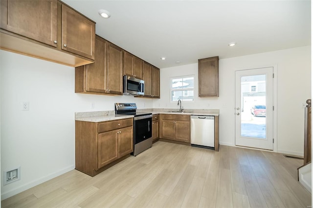 103 Cardow Dr Unit 169-605, Ofallon, MO 63368 - kitchen with stainless steel appliances, a sink, light countertops, light wood-type flooring, and recessed lighting