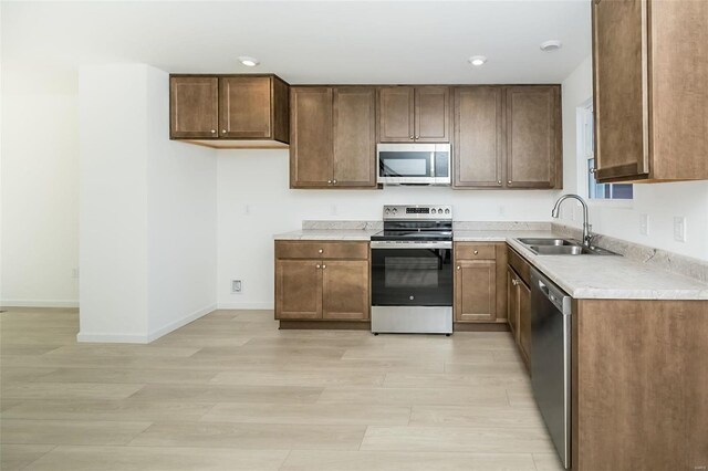 103 Cardow Dr Unit 169-605, Ofallon, MO 63368 - kitchen with stainless steel appliances, a sink, light countertops, light wood-style floors, and baseboards