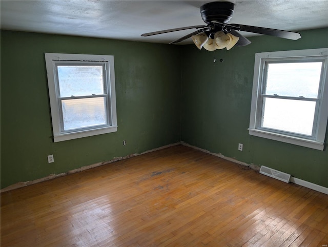 413 N 6th St, New Douglas, IL 62074 - unfurnished room with plenty of natural light, hardwood / wood-style flooring, a ceiling fan, and baseboards