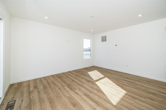 unfurnished room featuring light wood finished floors, baseboards, and recessed lighting