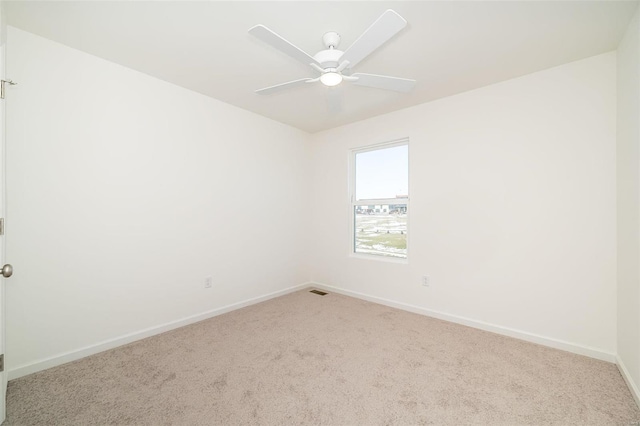carpeted empty room featuring baseboards and a ceiling fan