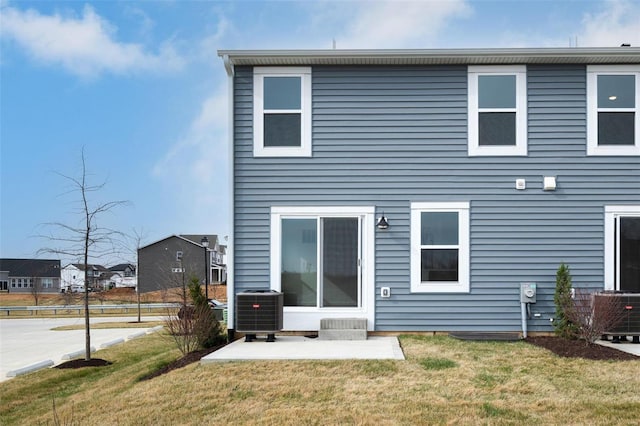 back of property featuring central AC unit, a yard, and a patio