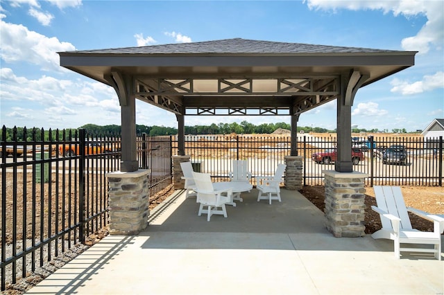 view of patio / terrace with a gazebo, fence, and a water view