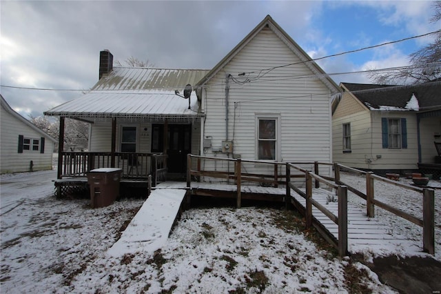 306 S Mine La Motte St, Fredericktown, MO 63645 - snow covered rear of property featuring a chimney, metal roof, and a porch