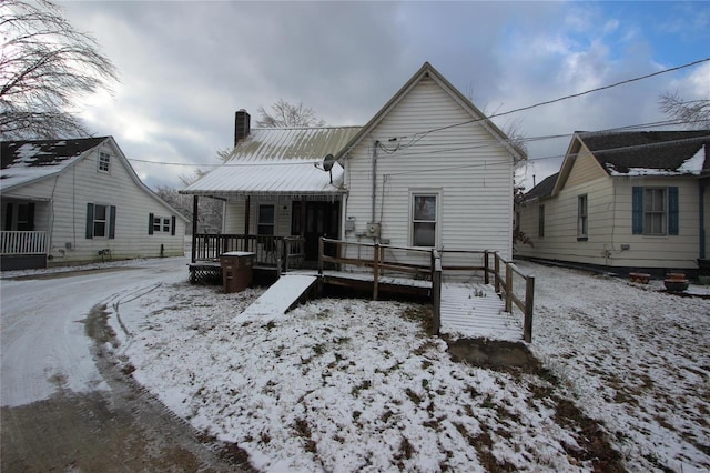 306 S Mine La Motte St, Fredericktown, MO 63645 - snow covered property with a chimney, metal roof, and a wooden deck