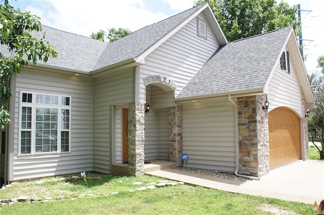 10 Anemone Rd, Lake Ozark, MO 65049 - view of front of property featuring roof with shingles, driveway, an attached garage, and stone siding