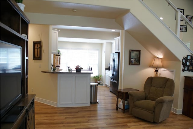 10 Anemone Rd, Lake Ozark, MO 65049 - kitchen with stainless steel fridge, wood finished floors, white cabinetry, a peninsula, and recessed lighting