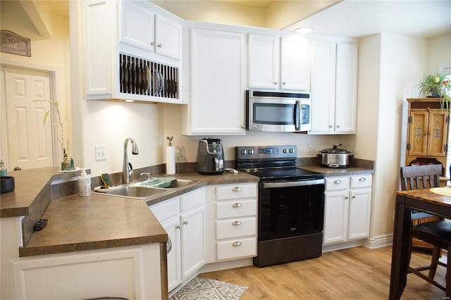 10 Anemone Rd, Lake Ozark, MO 65049 - kitchen featuring stainless steel microwave, electric stove, a sink, dark countertops, and light wood finished floors