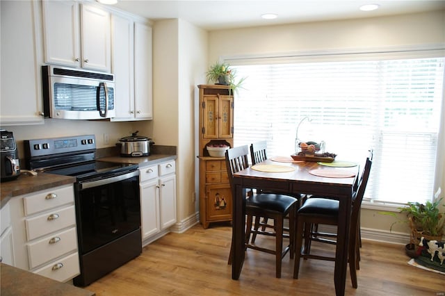 10 Anemone Rd, Lake Ozark, MO 65049 - kitchen with stainless steel appliances, dark countertops, white cabinets, light wood finished floors, and baseboards
