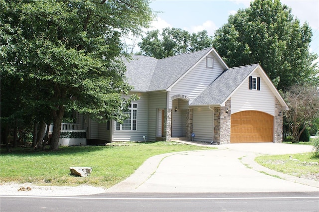 10 Anemone Rd, Lake Ozark, MO 65049 - view of front of house with a shingled roof, an attached garage, driveway, a front yard, and stone siding
