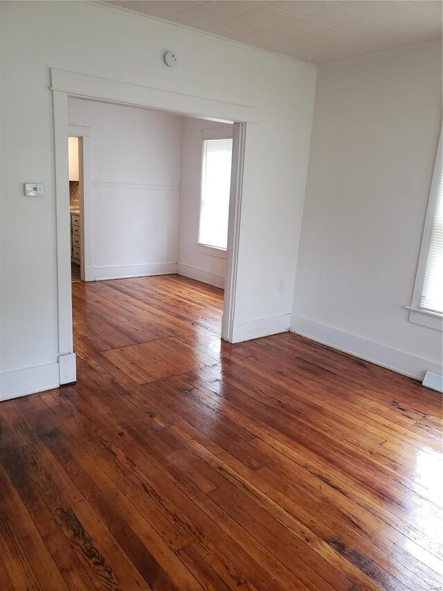 spare room featuring hardwood / wood-style flooring, a smoke detector, and baseboards
