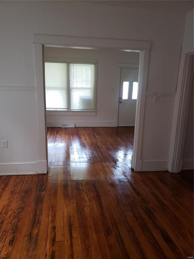 unfurnished room with hardwood / wood-style flooring and baseboards