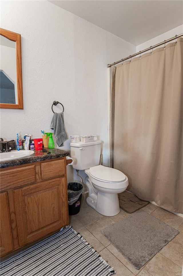 full bath featuring toilet, vanity, tile patterned floors, and curtained shower