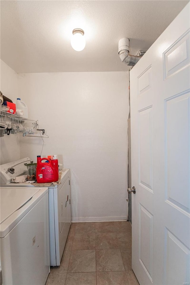 laundry room featuring separate washer and dryer, baseboards, and light tile patterned floors