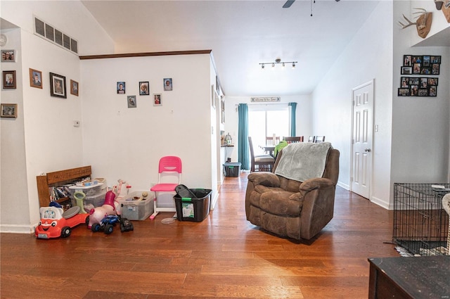 living room featuring wood finished floors, rail lighting, baseboards, and a ceiling fan