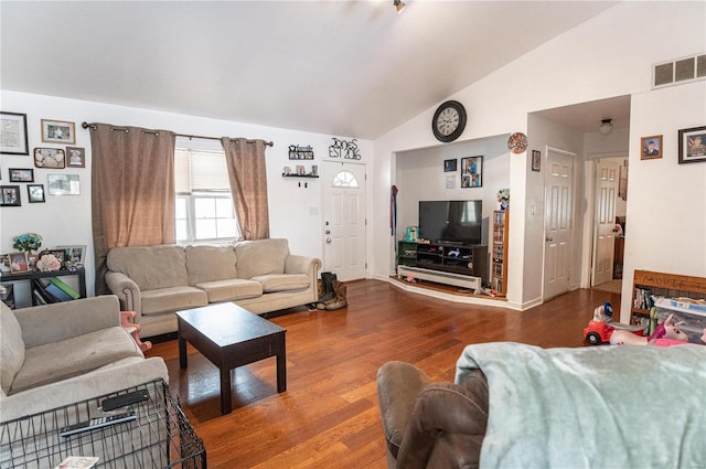 living area featuring lofted ceiling, wood finished floors, and baseboards