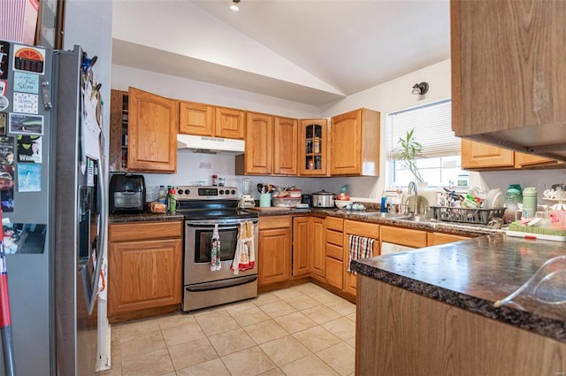 kitchen with appliances with stainless steel finishes, under cabinet range hood, a sink, vaulted ceiling, and light tile patterned flooring