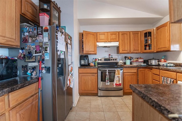 kitchen with stainless steel appliances, under cabinet range hood, lofted ceiling, glass insert cabinets, and light tile patterned floors