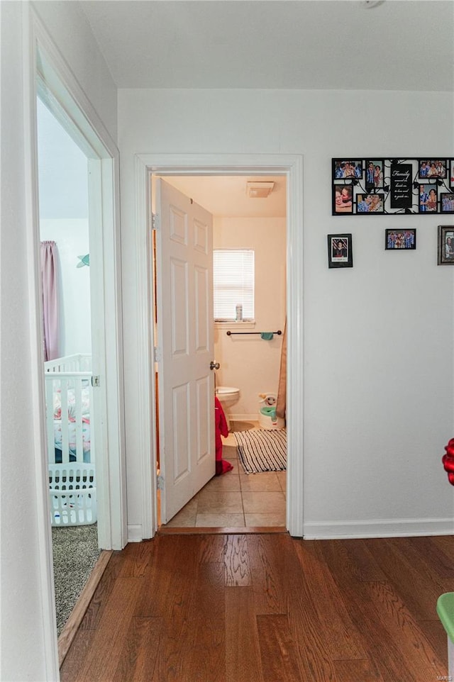 corridor featuring wood finished floors and baseboards