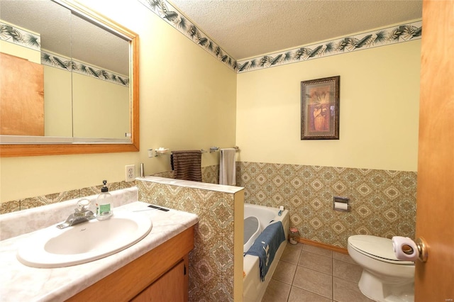 full bathroom with a textured ceiling, toilet, a garden tub, tile patterned flooring, and wallpapered walls