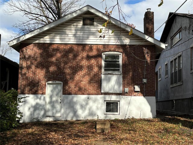 6514 Julian Ave, Saint Louis, MO 63133 - view of property exterior featuring brick siding and a chimney
