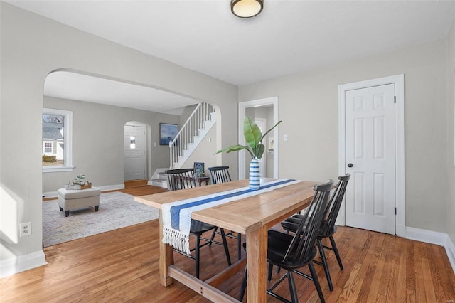 1100 Northdale Ave, Saint Louis, MO 63138 - dining space featuring arched walkways, light wood finished floors, baseboards, and stairway