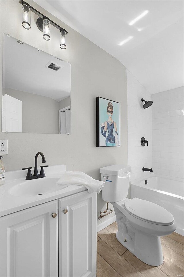 1100 Northdale Ave, Saint Louis, MO 63138 - bathroom featuring toilet, wood finished floors, vanity, tub / shower combination, and lofted ceiling