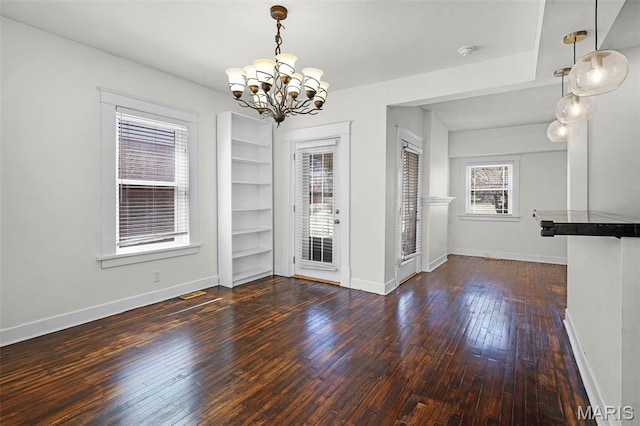2326 Bellevue Ave, Saint Louis, MO 63143 - unfurnished dining area featuring a chandelier, wood-type flooring, and baseboards