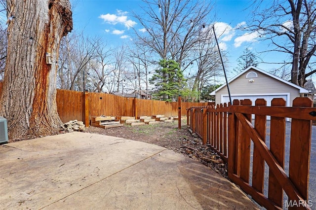 2326 Bellevue Ave, Saint Louis, MO 63143 - fenced yard featuring a detached garage, an outbuilding, and a patio