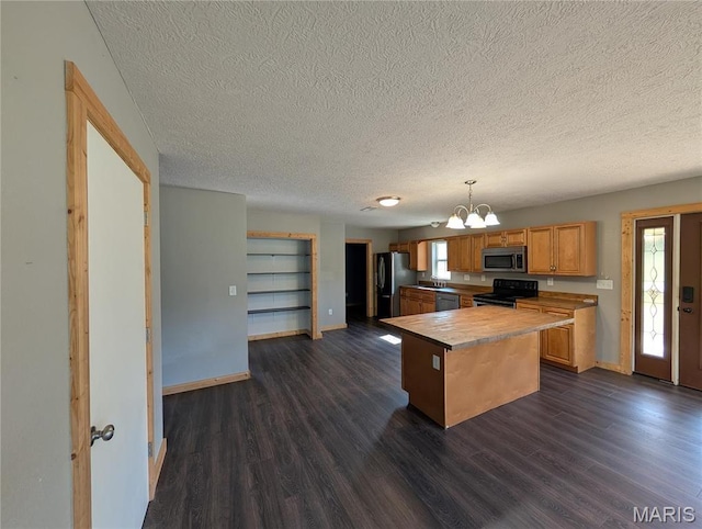 kitchen featuring appliances with stainless steel finishes, a chandelier, a textured ceiling, baseboards, and dark wood-type flooring